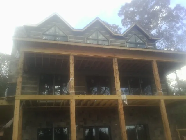 Dormers and porch framing on a large log home under construction — Roof Coating work by our crew in Belcamp
