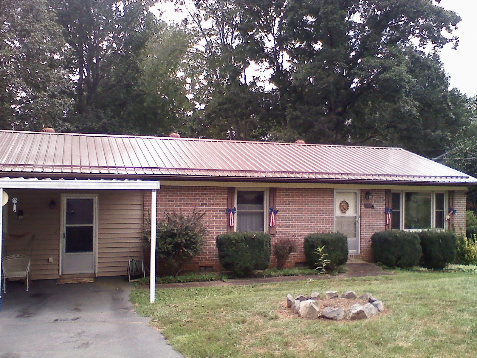 Bronze metal roof and carport on a brick ranch home — Roof Repair work by our crew in Belcamp