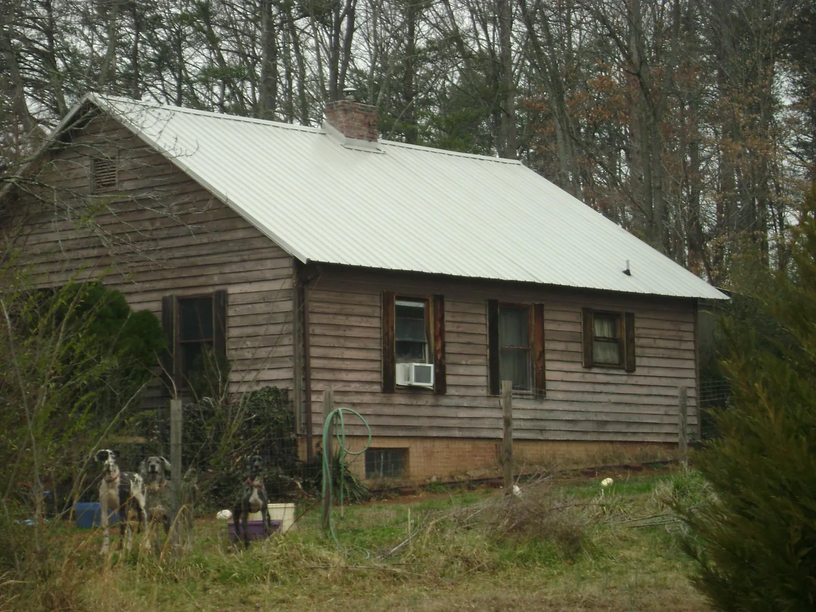 White metal roof on an old wood sided farmhouse, from a Metal Roof Installation job in Belcamp
